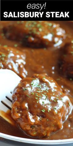 meatballs covered in gravy on a plate with a fork