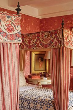 an ornate canopy bed in a bedroom with pink walls