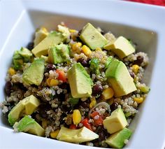 a white bowl filled with rice, avocado and black beans on top of a table