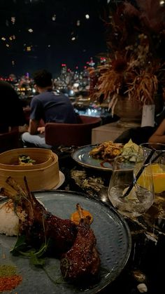 two plates with food on them and people sitting at a table in the background,