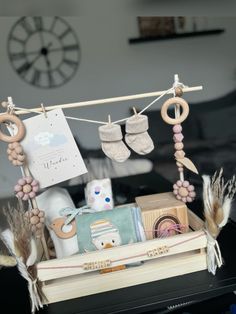 a wooden box with baby items hanging from it's clothesline