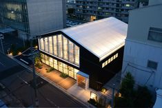 an aerial view of a building at night with its lights on and windows lit up