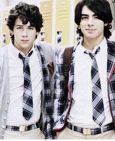 two young men standing next to each other in front of lockers with ties on