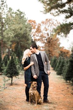 a man and woman standing next to a dog