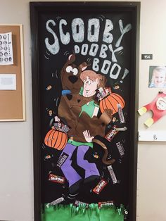 a door decorated with an image of a dog holding a pumpkin and candy bar on it