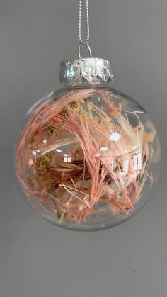 a glass ornament filled with lots of pink twigs