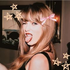 a woman sticking out her tongue with stars around her head and on the wall behind her