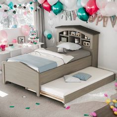 a bedroom decorated for a birthday with balloons and confetti on the wall above the bed