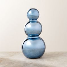 a blue vase sitting on top of a table next to a white wall and floor