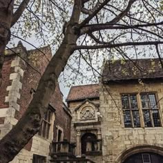 an old stone building with a tree in the foreground