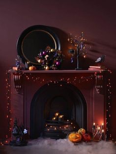 a fireplace decorated with halloween decorations and lights