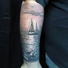 a man with a sailboat tattoo on his arm