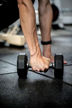 a man is doing push ups with two dumbbells