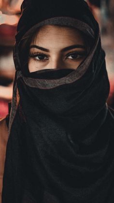 a woman wearing a black shawl and looking into the distance with her eyes wide open