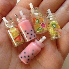 three miniature bottles filled with liquid and lemon slices on top of each other in the palm