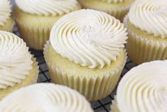 cupcakes with white frosting sitting on a cooling rack