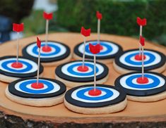 decorated cookies with red, white and blue arrows on them are arranged in the shape of darts