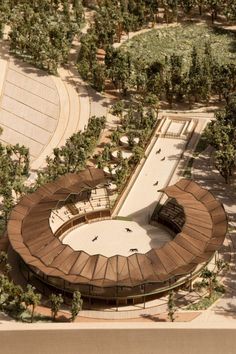 an aerial view of a circular building with trees around it