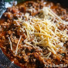 a close up of a bowl of food with cheese on top and ground beef in the middle