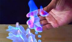 two hands are shown with blue light coming out of them, and one hand is holding something