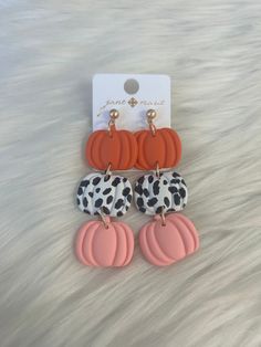 three pairs of orange, black and white pumpkin earrings