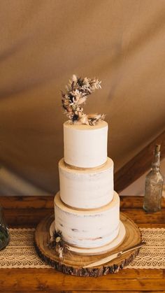 a three tiered cake sitting on top of a wooden table