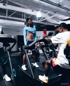 a group of people working out on treadmills in a gym with one man taking a selfie