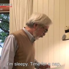 an older man standing in front of a tv holding a piece of paper with the words i'm sleepy time for a nap