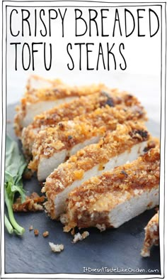 crispy breaded tofu steaks on a black plate with greens and seasoning