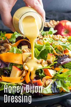 a person pouring dressing onto a salad with apples and walnuts in the background text reads honey dijon dressing