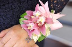 a close up of a person's hand with a flower on their ring finger