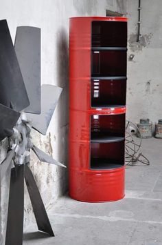 a large metal object sitting next to a red barrel