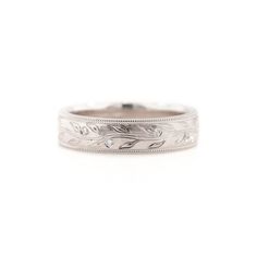 a white gold wedding ring with leaves and diamonds