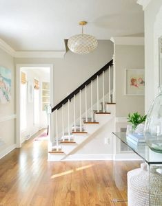 a glass table sitting in the middle of a living room next to a stair case