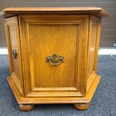 an old wooden cabinet with brass hardware on the front and side doors is sitting in a parking lot