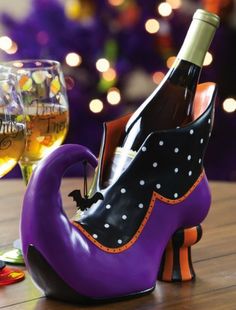 a purple shoe shaped wine bottle holder on a table next to a glass of wine