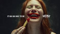 a woman with red hair is holding a piece of food in front of her mouth