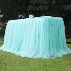 a table covered with a blue cloth in the grass