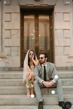 a man and woman sitting on the steps of a building