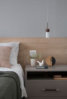 a bed with two nightstands and a lamp on top of it next to a night stand