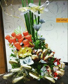 a vase filled with lots of different types of flowers and candy wrappers on top of a table