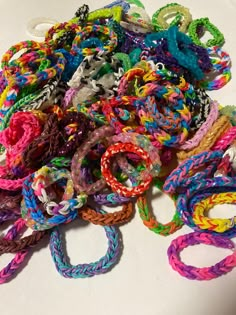 a pile of colorful bracelets sitting on top of a white table