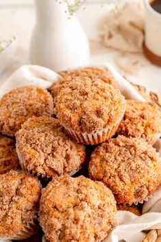 a pile of cinnamon crumb muffins sitting on top of a white cloth