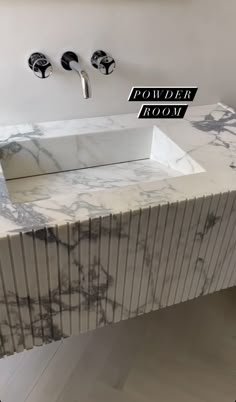 a marble sink with the words powder room above it