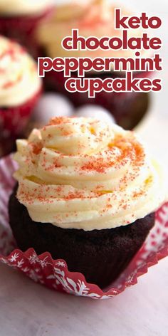 chocolate cupcakes with white frosting and sprinkles in red paper wrappers