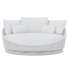 a white round couch with pillows on it's back and sides, in front of a white background