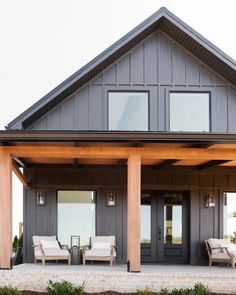 a house with two covered porches and chairs on the front