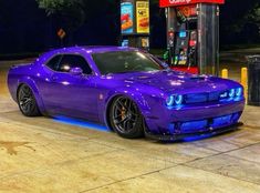 a purple car parked in front of a gas station