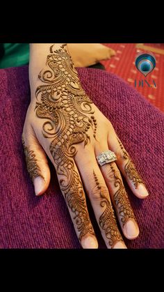 a woman's hand with henna tattoos on it