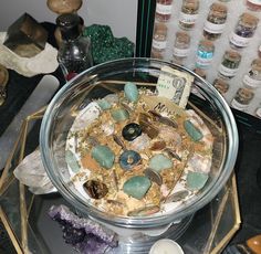 a glass bowl filled with lots of different types of rocks and stones on top of a table